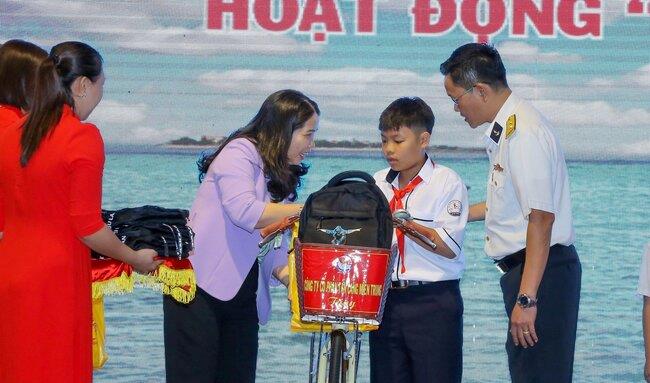 Con ngư dân mồ côi nhận xe đạp, ba lô đi học, vở, viết của Tổng Công ty Tân Cảng Sài Gòn và Sở LĐ-TB&XH tặng.