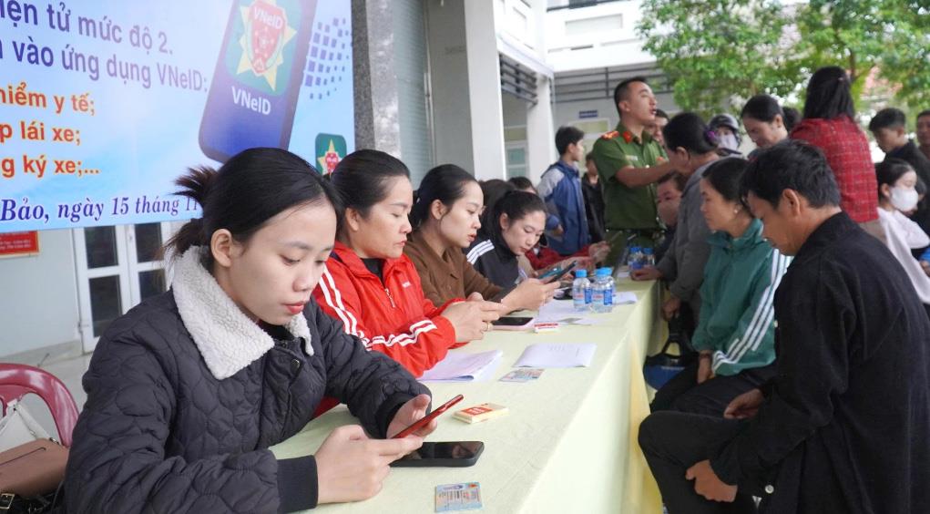 Cán bộ UBND và Công an xã Lao Bảo hướng dẫn người dân kích hoạt định danh điện tử VNeID mức 2 và tích hợp các giấy tờ quan trọng lên ứng dụng.