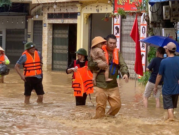 CBCS Phòng CSGT Công an tỉnh Lào Cai giải cứu nhiều em nhỏ ra khỏi nơi ngập sâu.